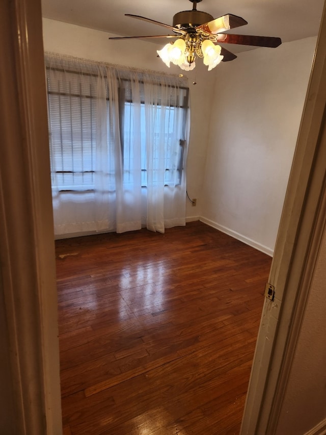 empty room with ceiling fan and dark hardwood / wood-style floors