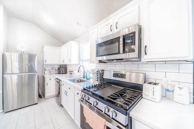 kitchen with white cabinetry, sink, lofted ceiling, and appliances with stainless steel finishes