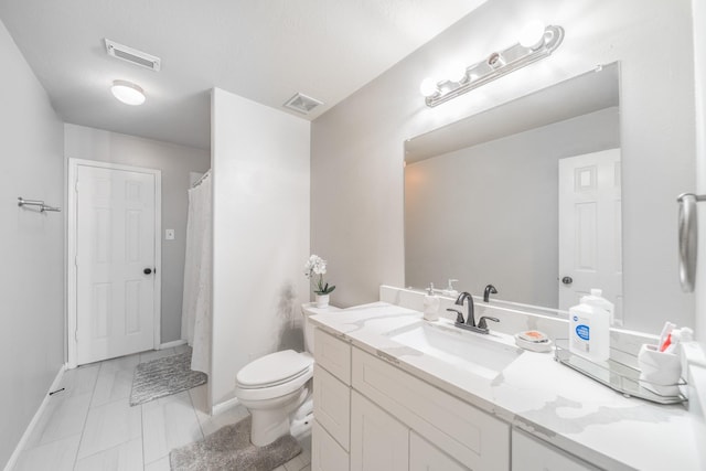 bathroom with tile patterned flooring, vanity, and toilet