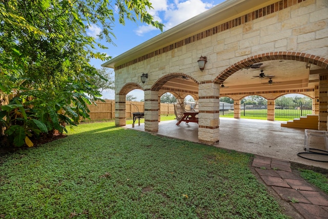 view of yard with ceiling fan and a patio area