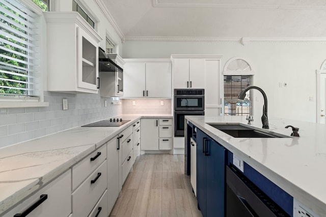 kitchen with backsplash, white cabinets, sink, black electric cooktop, and stainless steel double oven