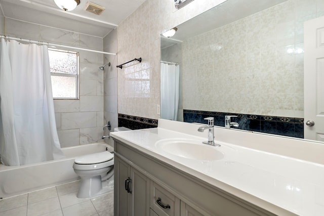 full bathroom featuring tile patterned floors, shower / bath combo, toilet, and tile walls