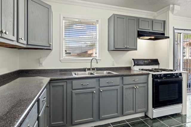 kitchen featuring dark tile patterned flooring, white gas stove, gray cabinets, and sink