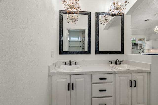 bathroom featuring vanity, crown molding, and an inviting chandelier