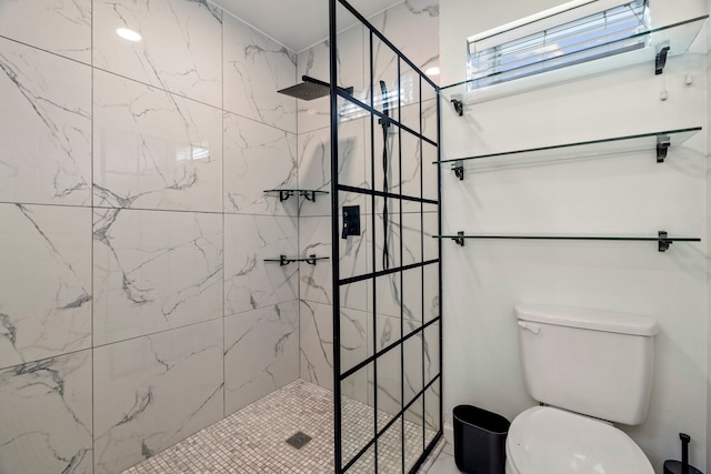 bathroom with a tile shower and toilet