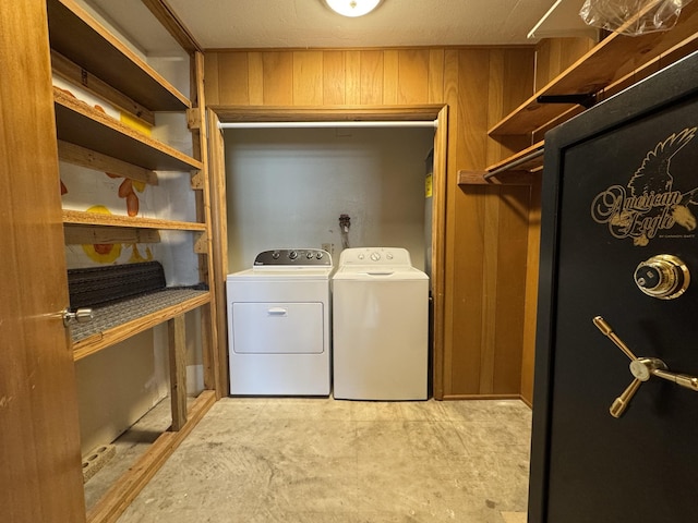 laundry area with wooden walls and washing machine and clothes dryer