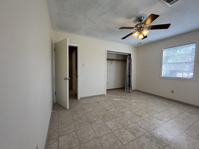 unfurnished bedroom featuring ceiling fan and a closet