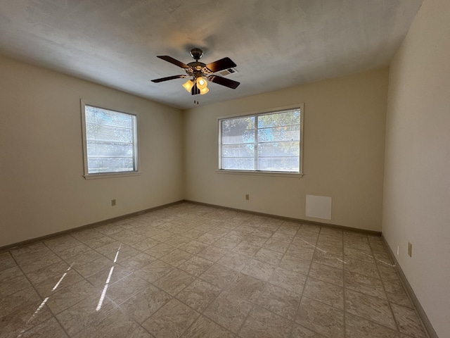 unfurnished room featuring a wealth of natural light and ceiling fan