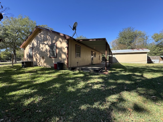 back of property with central AC and a lawn