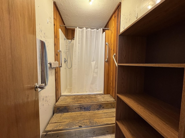 interior space with a textured ceiling and curtained shower