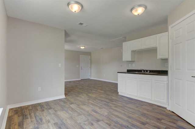 kitchen featuring dark hardwood / wood-style flooring, white cabinetry, and sink