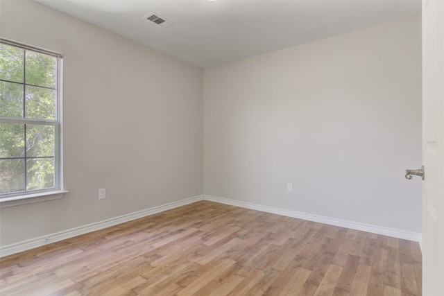 spare room featuring light hardwood / wood-style flooring and plenty of natural light