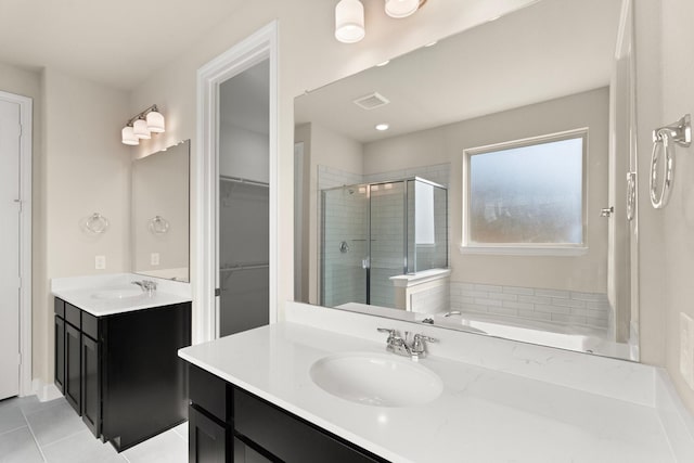 bathroom featuring plus walk in shower, vanity, and tile patterned flooring