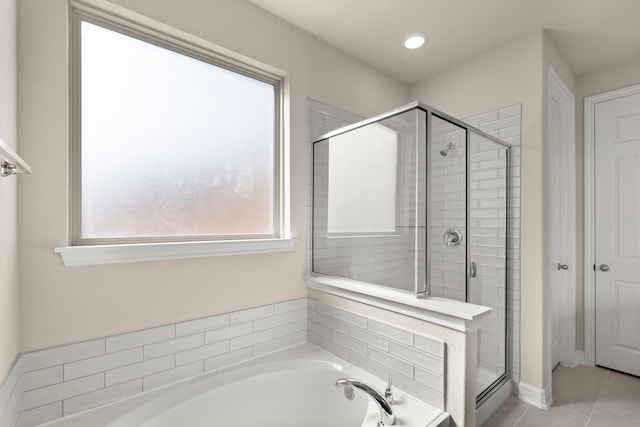 bathroom with tile patterned flooring, plus walk in shower, and a wealth of natural light