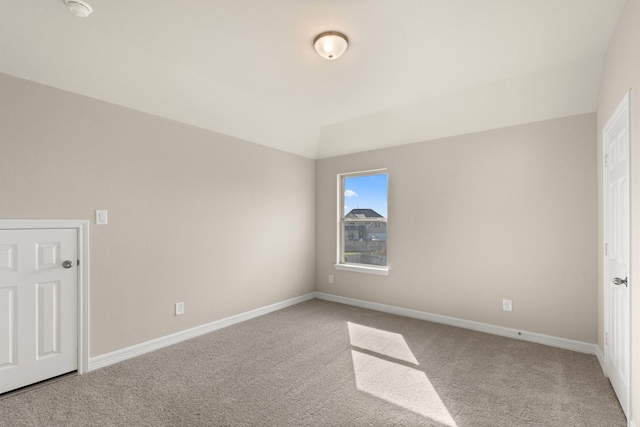 unfurnished bedroom with carpet and lofted ceiling