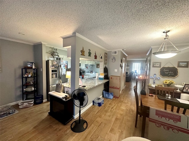 kitchen featuring decorative light fixtures, stainless steel fridge with ice dispenser, crown molding, and light hardwood / wood-style flooring