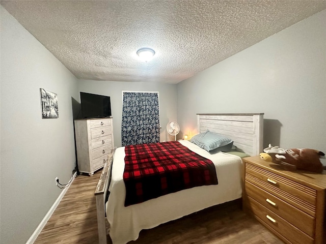 bedroom with a textured ceiling and dark wood-type flooring