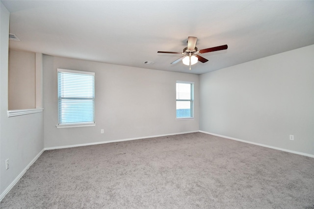 spare room with ceiling fan and carpet