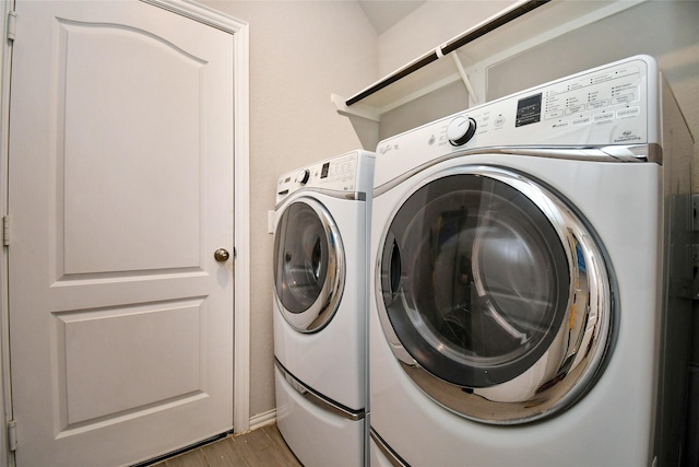 laundry area with light hardwood / wood-style flooring and independent washer and dryer