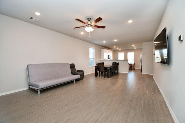 living area featuring ceiling fan and light wood-type flooring