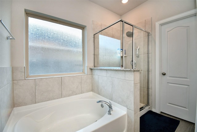 bathroom featuring shower with separate bathtub