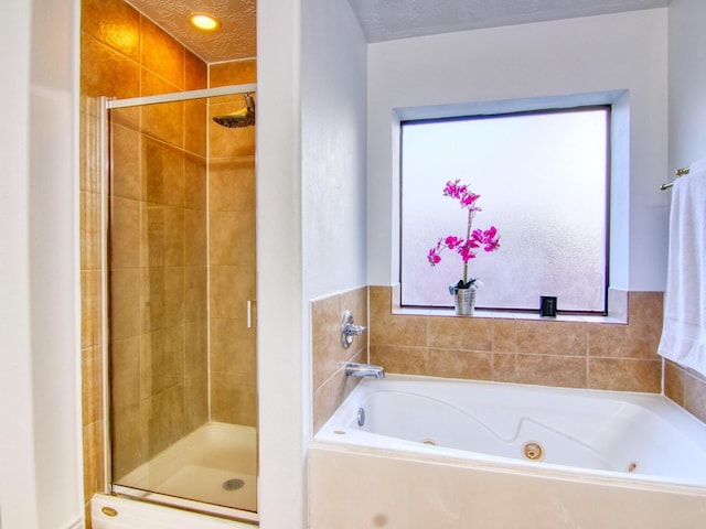 bathroom featuring a healthy amount of sunlight, a textured ceiling, and separate shower and tub