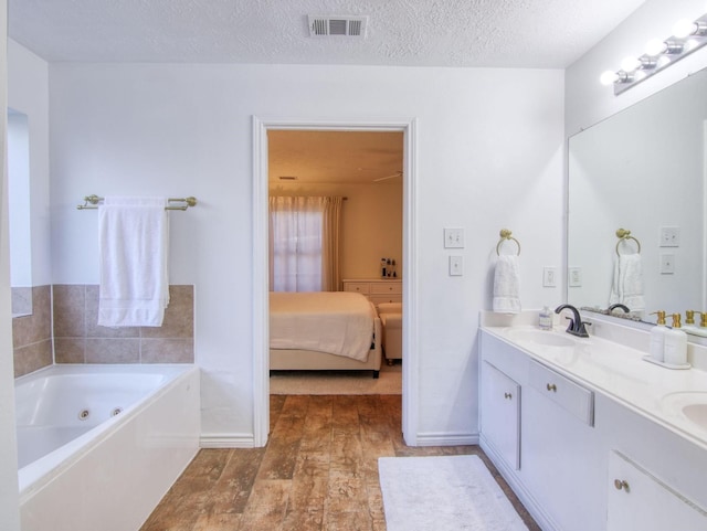 bathroom with a bathtub, vanity, and a textured ceiling