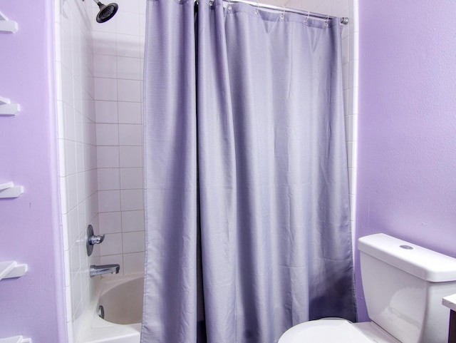 bathroom featuring shower / tub combo and toilet