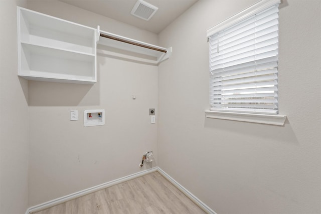 clothes washing area featuring electric dryer hookup, hookup for a gas dryer, light wood-type flooring, and hookup for a washing machine