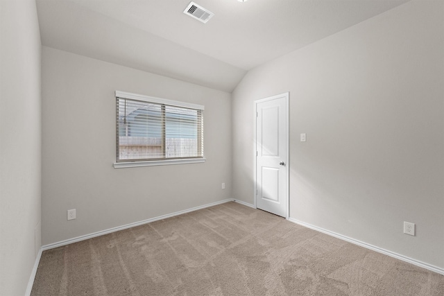 unfurnished room featuring light colored carpet and lofted ceiling