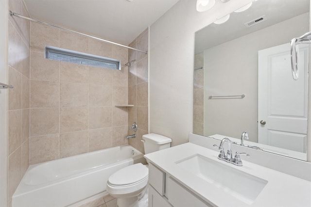 full bathroom with tile patterned floors, vanity, tiled shower / bath combo, and toilet