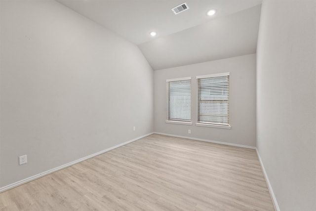 empty room with light hardwood / wood-style floors and lofted ceiling