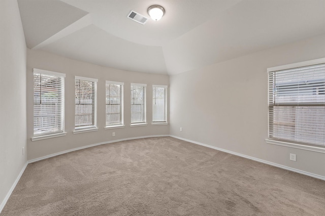 carpeted spare room with lofted ceiling