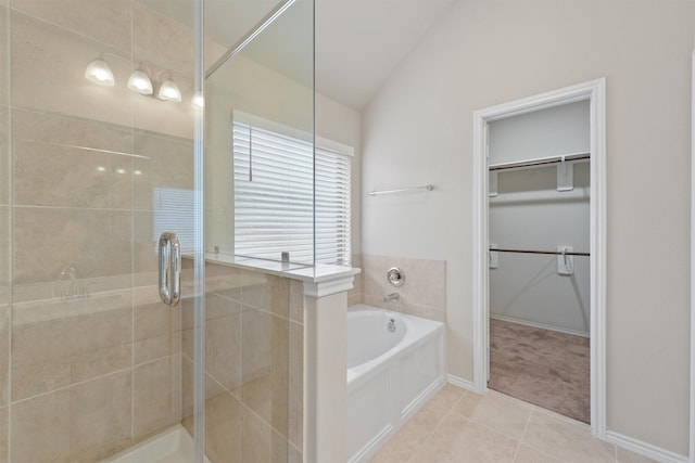 bathroom with tile patterned flooring, shower with separate bathtub, and vaulted ceiling