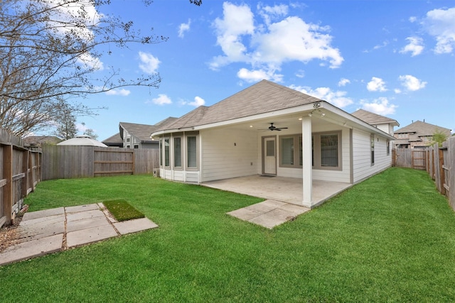 back of house featuring ceiling fan, a yard, and a patio