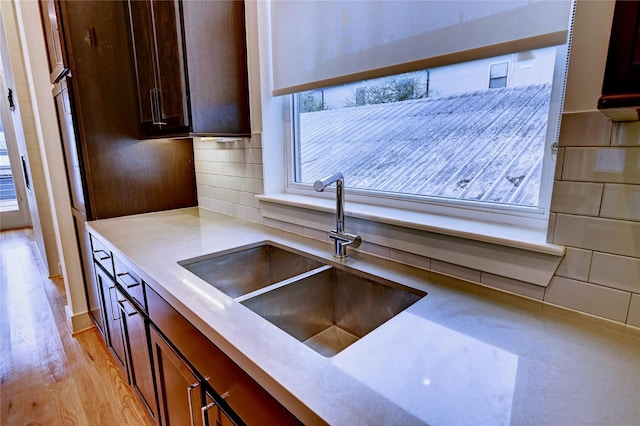 kitchen featuring tasteful backsplash, light hardwood / wood-style flooring, a wealth of natural light, and sink