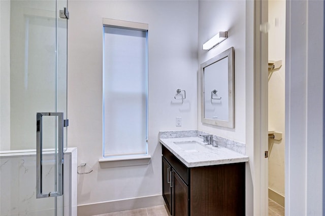 bathroom with tile patterned flooring, vanity, and walk in shower