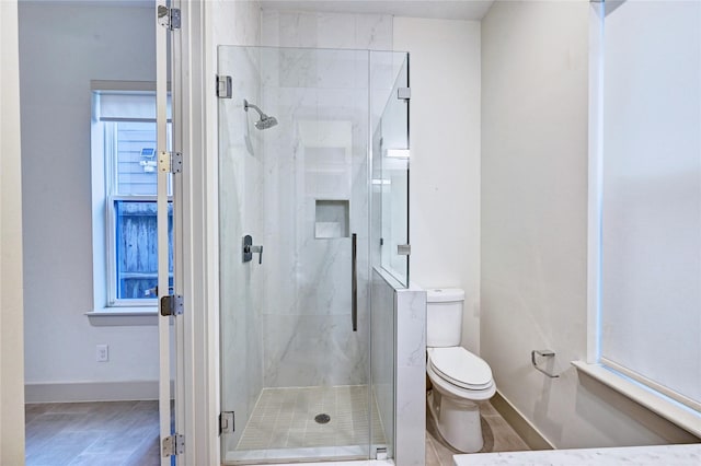 bathroom with a shower with door and toilet