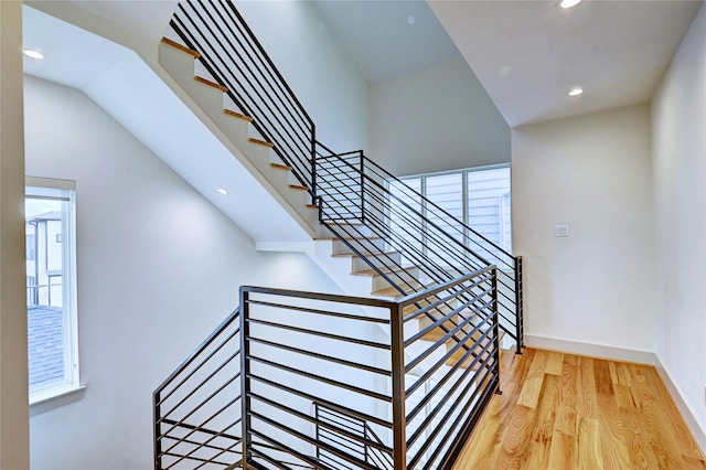 stairs featuring hardwood / wood-style floors and a healthy amount of sunlight