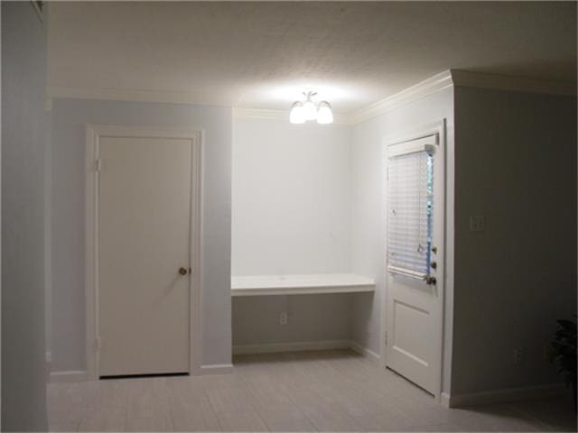 interior space with ornamental molding and a notable chandelier