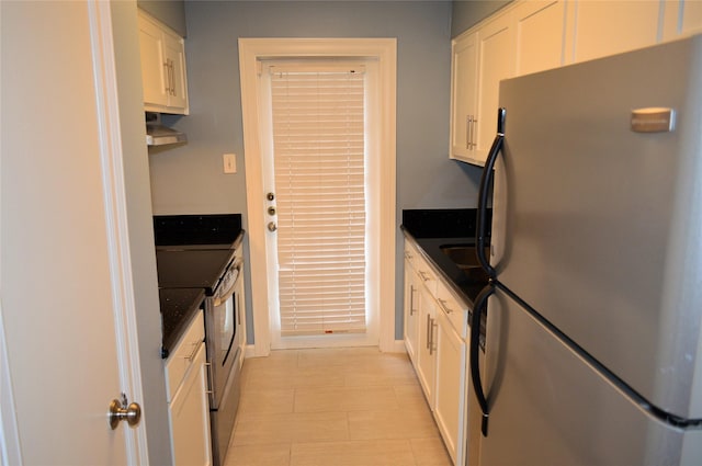 kitchen with white cabinets, appliances with stainless steel finishes, and dark stone counters