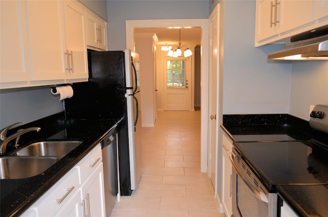 kitchen featuring white cabinetry, sink, stainless steel appliances, dark stone countertops, and a chandelier