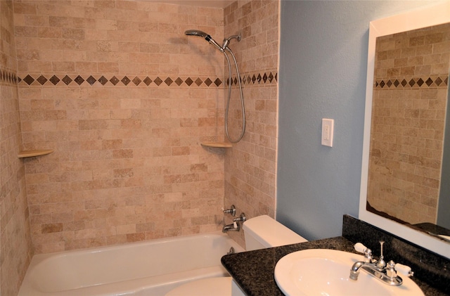 full bathroom with vanity, tiled shower / bath, and toilet