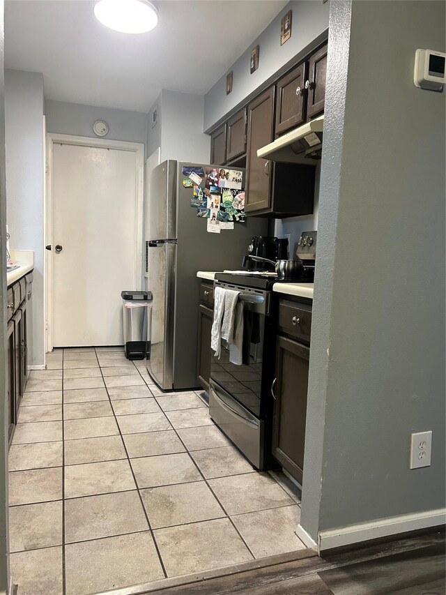 kitchen featuring dark brown cabinetry, light tile patterned floors, and stainless steel appliances