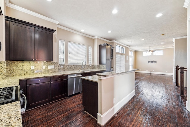 kitchen with a center island, ceiling fan, light stone countertops, appliances with stainless steel finishes, and dark brown cabinets