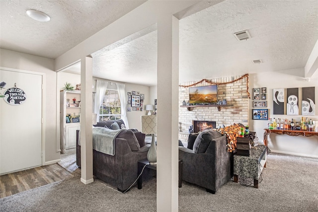 carpeted living room featuring a fireplace and a textured ceiling