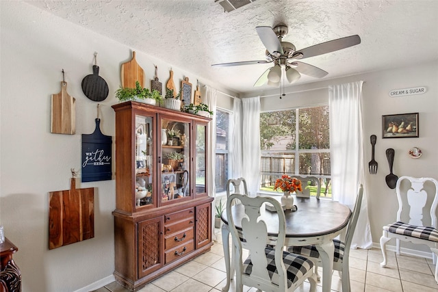 tiled dining room featuring ceiling fan and a textured ceiling