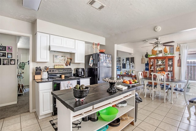 kitchen with white cabinetry, light tile patterned floors, black appliances, and a textured ceiling