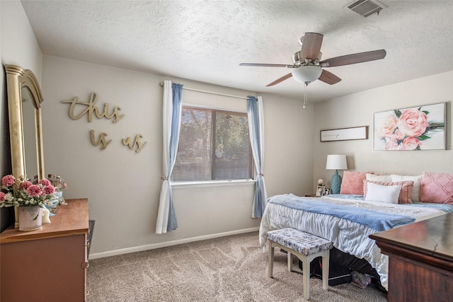 carpeted bedroom with ceiling fan and a textured ceiling