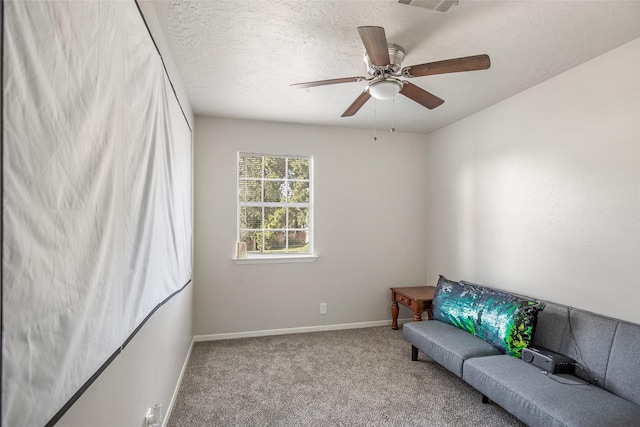 sitting room with carpet, ceiling fan, and a textured ceiling